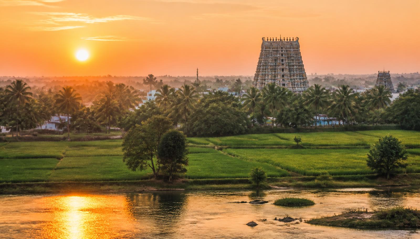 Sunrise over a temple gopuram and paddy fields near Lalgudi